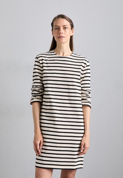 Robe rayée en beige et noir, dotée de longues manches, d'un col rond et d'une silhouette droite avec des fentes sur les côtés à l'ourlet.