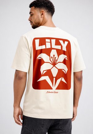 Man wearing cream t-shirt with large red graphic of a stylized lily flower and the words "LILY" and "Neverless" on the back.