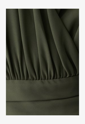 Olivovo zelená tkanina s textúrovaným povrchom, s pliatkami hore a hladkým pásom na spodnej časti. Mäkko splývavý vzhľad po celom povrchu.