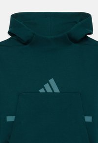 Teal hettegenser med høy krage, med en stor lomme foran og en subtil Adidas-logo i en lysere nyanse. Mykt materiale og glatt tekstur.