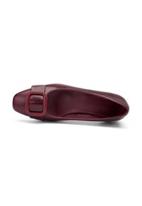 Scarpa piatta in pelle bordeaux con punta quadrata e una grande fibbia decorativa di lato. Texture liscia con un design minimalista e senza motivi visibili.