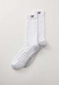 Calcetines deportivos blancos con una textura acanalada, acentos grises con patrón en la punta y el talón, y un logotipo en el puño.