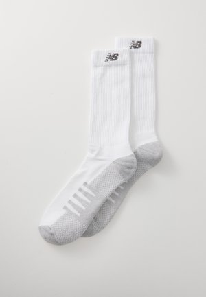 White athletic socks with a ribbed texture, gray patterned accents on the toe and heel, and a logo on the cuff.