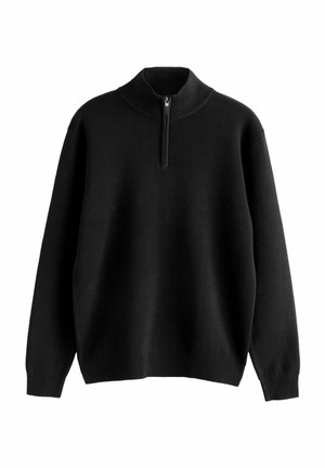 Juodas megztinis su aukštu apykakle, turintis pusiau užtrauktuką priekyje. Dizainas apima guma pabaigose ir rankovėse, kad suteiktų prigludusią išvaizdą.