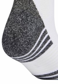 Λευκή κάλτσα με γκρι υφασμάτινη μύτη, διακοσμημένη με μαύρο και γκρι μοτίβο, και πολλαπλές οριζόντιες λευκές ρίγες κοντά στον αστράγαλο.
