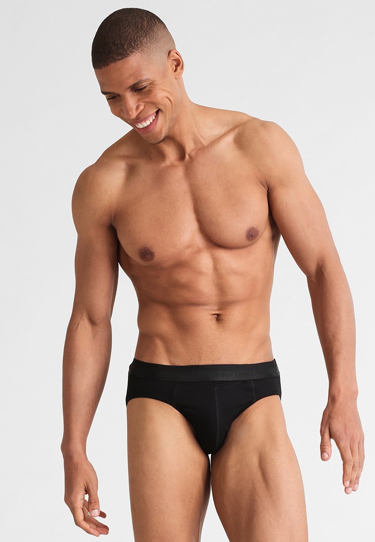 Slips neri realizzati in tessuto elastico, con una comoda cintura e un design aderente che si adatta al corpo.