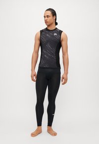 Meeste must sportlik tank top tekstureeritud disainiga ja logoga, koos keha sisse sobivate mustade retuusidega. Sile kangas, ilma varrukateta lõige.