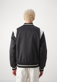 Puma FOR THE FANBASE VARSITY - Bombejakke - black