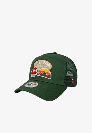 Casquette trucker en mesh vert foncé avec des écussons indiquant "New Era Outdoor," un coucher de soleil en montagne, et un champignon rouge et blanc.