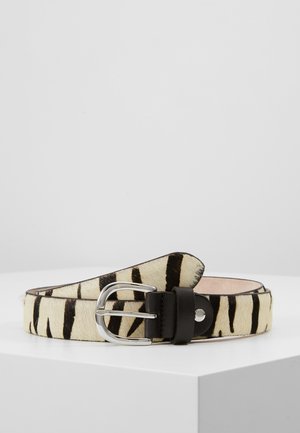 Skórzany pasek z wzorem w cętki zebry, srebrną metalową klamrą oraz czarną skórzaną pętlą, leżący na białej powierzchni.