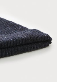 Navy blue knitted beanie with a ribbed texture and subtle flecks, featuring a folded cuff at the bottom for added warmth and style.