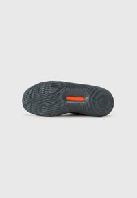 Talpa de pantof sport de culoare gri închis, cu un model texturat, evidențiat de un accent portocaliu pronunțat și cu logo-ul "UNDER ARMOUR".