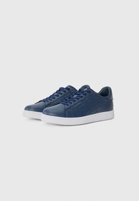 Navy blue leather sneakers with white rubber soles, featuring textured side accents and flat laces. Classic low-top design.