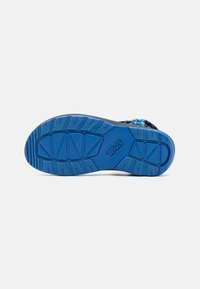 Swarte og blå sportsandalar med såle, som har dype spor for godt grep, formet kontur og teksturert blå gummimateriale.