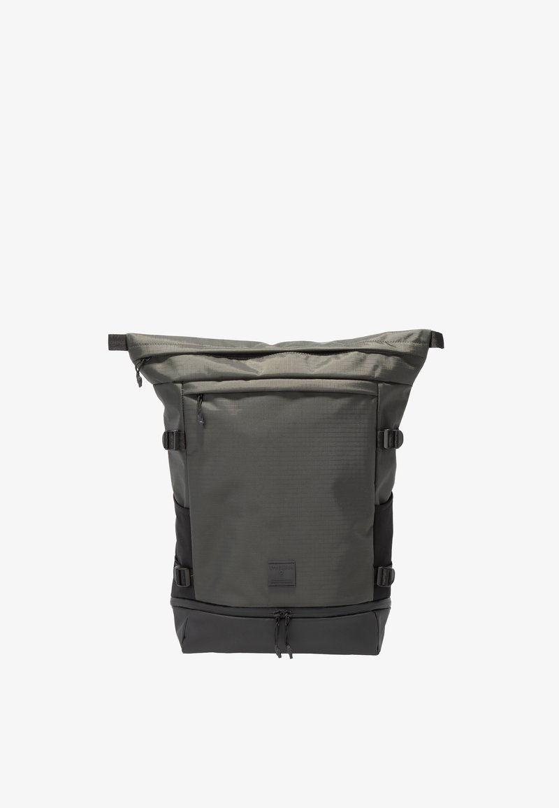 Mochila enrollable de color gris oscuro con bolsillo delantero con cremallera, correas laterales de compresión y compartimento inferior con cremallera, mostrada sobre fondo blanco.