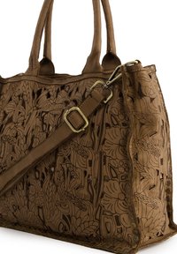Braune Lederhandtasche mit aufwändigen floralen Ausschnittmustern, doppelten Griffen und einem verstellbaren Schulterriemen mit einer Metallschnalle.