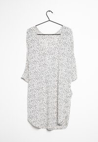 Vestido ligero confeccionado en tela blanca con un patrón abstracto negro. Tiene un corte holgado, mangas anchas y escote redondeado.