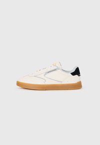 White low-top sneaker with gum sole, black heel tab, lace-up front, and "Scotch & Soda" branding on the side and heel.