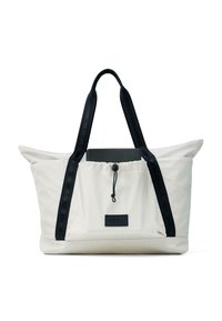 Balta auduma somiņa ar melnām siksnām un auklas aizdari, ar melnu etiķeti. Somiņai ir strukturēta forma un mīksta tekstūra.