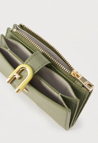 Portofel verde din piele cu o suprafață texturată. Dispune de un fermoar auriu, mai multe sloturi pentru carduri și o închizătoare accent galbenă.