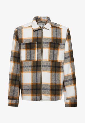 Flanneljakke med lynlås, prydet med et hvidt, gråt og brunt ternet mønster med orange accenter. To forreste lommer er synlige.