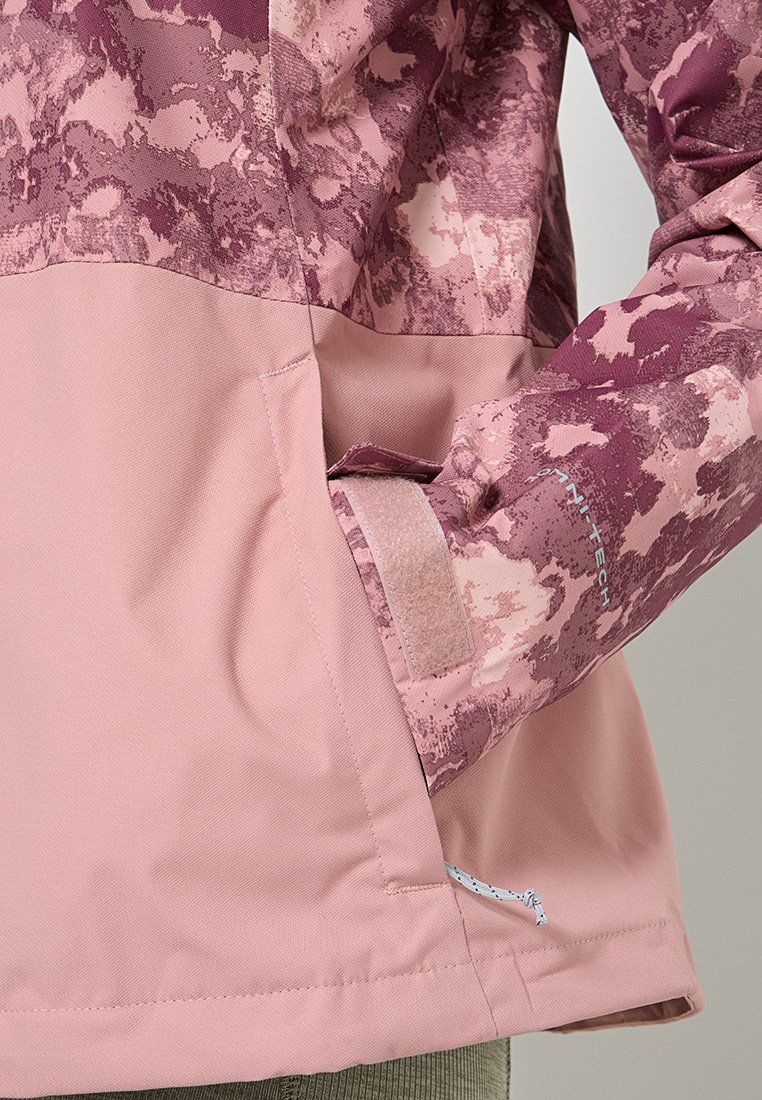 Helle rosa wasserdichte Jacke mit einem strukturierten Stoff im lila Camouflage-Muster, verstellbaren Bündchen und einer Seitentasche.