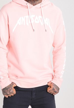 Felpa con cappuccio di colore rosa chiaro con il logo bianco "ANTISOCIAL" sul petto. Presenta maniche lunghe con scritte decorative su entrambi i lati. Materiale in misto cotone.