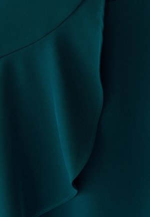 Temno modra tkanina z gladko teksturo, naravnimi gubami in vidnimi šivi ob robovih, kar ustvarja plasten efekt.