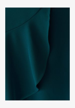 Temno modra tkanina z gladko teksturo, naravnimi gubami in vidnimi šivi ob robovih, kar ustvarja plasten efekt.