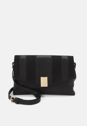 Sac bandoulière en cuir noir avec panneaux cousus verticalement, fermoir rectangulaire doré et sangle réglable avec boucle dorée.