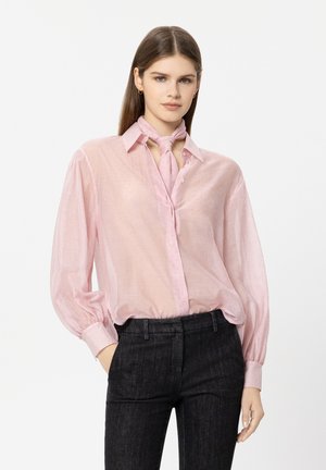 Light pink sheer blouse with a collar, button front, and long balloon sleeves. Features a tied scarf neckline and subtle sparkles. Worn with dark pants.