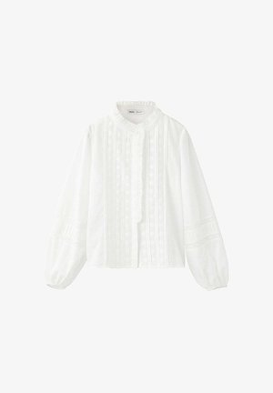 Blouse blanche à manches longues avec col à volants, dentelle verticale et plis sur le devant, et manches bouffantes avec inserts en dentelle.