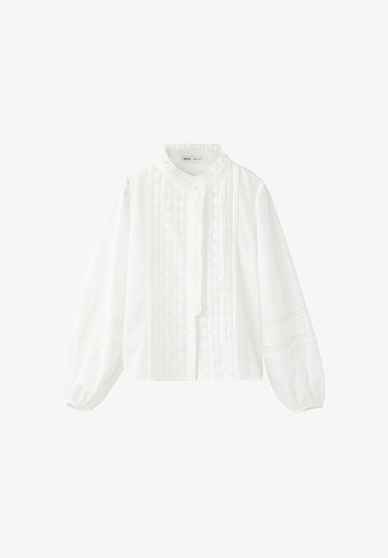 Blouse blanche à manches longues avec col à volants, dentelle verticale et plis sur le devant, et manches bouffantes avec inserts en dentelle.