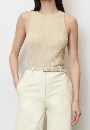Beige ribbet tanktop med rund halsudskæring, parret med lysegule bredbenede bukser og et matchende bælte.