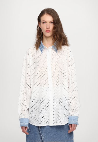 Weißes gesticktes Hemd mit hellem Denim-Kragen, mit Knopfleiste und langen Ärmeln. Auffällig durch das filigrane Lochmuster.