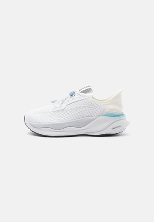 Biały sportowy sneaker z teksturowaną dzianinową cholewką, wyściełaną podeszwą, jasnoniebieskim akcentem na pięcie i pętlą z napisem na jednolitym tle.