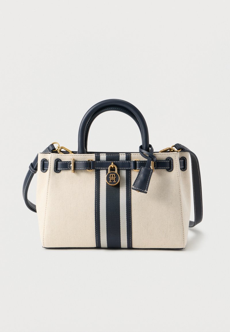 Τσάντα χειρός από καμβά σε μπεζ χρώμα με δύο μπλε ναυτικούς ρίγες. Διαθέτει στρογγυλεμένες λαβές, αφαιρούμενο λουράκι, εξαρτήματα σε χρυσό τόνο και διακριτικό λογότυπο.