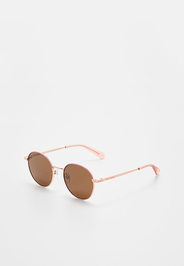 Round sunglasses with thin rose gold metal frame and brown tinted lenses on white background.