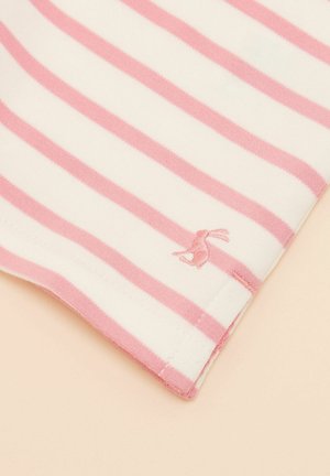 Róg tkaniny w poziome białe i różowe paski z małym różowym haftowanym zajączkiem na jasnobeżowym tle.