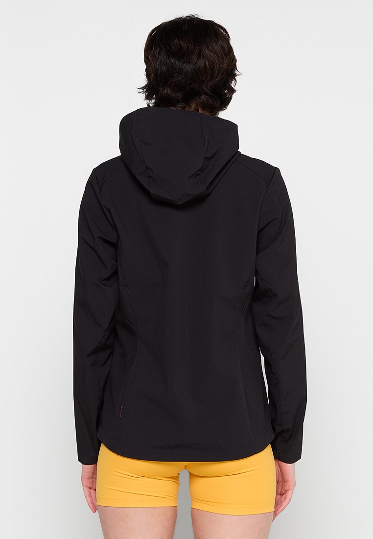 Schwarze wasserdichte Jacke mit Kapuze, die ein tailliertes Design, eine glatte Textur und nahtlose Schultern aufweist. Über gelben Shorts getragen.