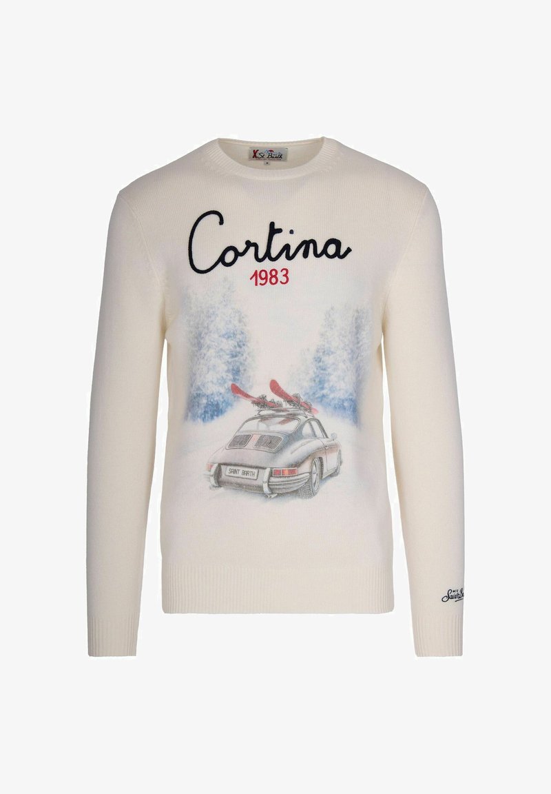 Pull blanc avec le texte "Cortina 1983", une voiture vintage transportant des skis rouges, et des arbres couverts de neige en arrière-plan sur le devant.