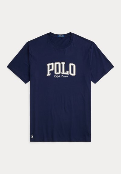 Sötétkék pamut póló kerek nyakkal, rövid ujjú, fehér "POLO Ralph Lauren" logóval a mellkasán. Egy kis logó található az alján.