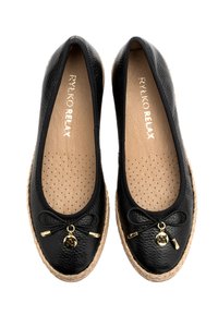 Ballerine in pelle nera con finitura texturizzata, punta rotonda, dettaglio in elastico a fiocco e accessori in ottone. La suola avvolta in juta aggiunge un tocco naturale.