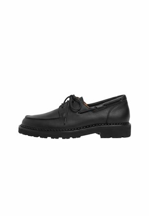 Chaussure bateau noire en cuir à lacets, semelle cousue et semelle extérieure en caoutchouc rainurée, vue de profil sur fond blanc.