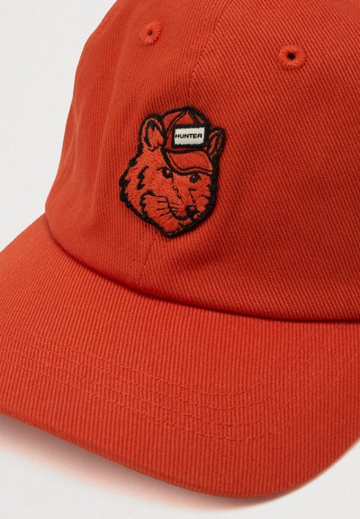 Orange cap made of ribbed fabric featuring an embroidered fox patch with a red cap and white label reading "HUNTER."