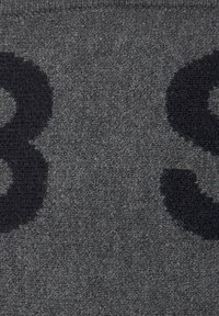 Grauer Stoff mit einer weichen Textur, der kräftige schwarze Zahlen zeigt und ein kontrastreiches Muster auf der Oberfläche bildet.