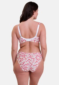 Set di bralette e bikini con stampa floreale in tessuto morbido. Presenta una fascia e spalline bianche, con motivi di fiori rosa e rossi su uno sfondo chiaro.