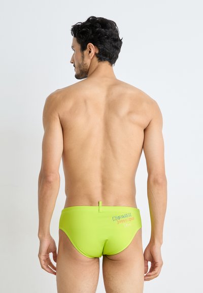 Lime green swim briefs made of stretch fabric, featuring a rear logo and a minimal design. The waistband includes a small loop detail.