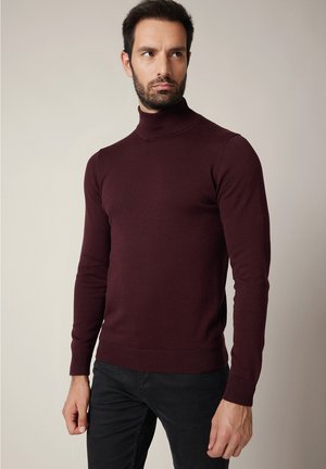 Bordowy golf wykonany z miękkiej dzianiny, z długimi rękawami, prążkowanymi mankietami i dopasowanym krojem.