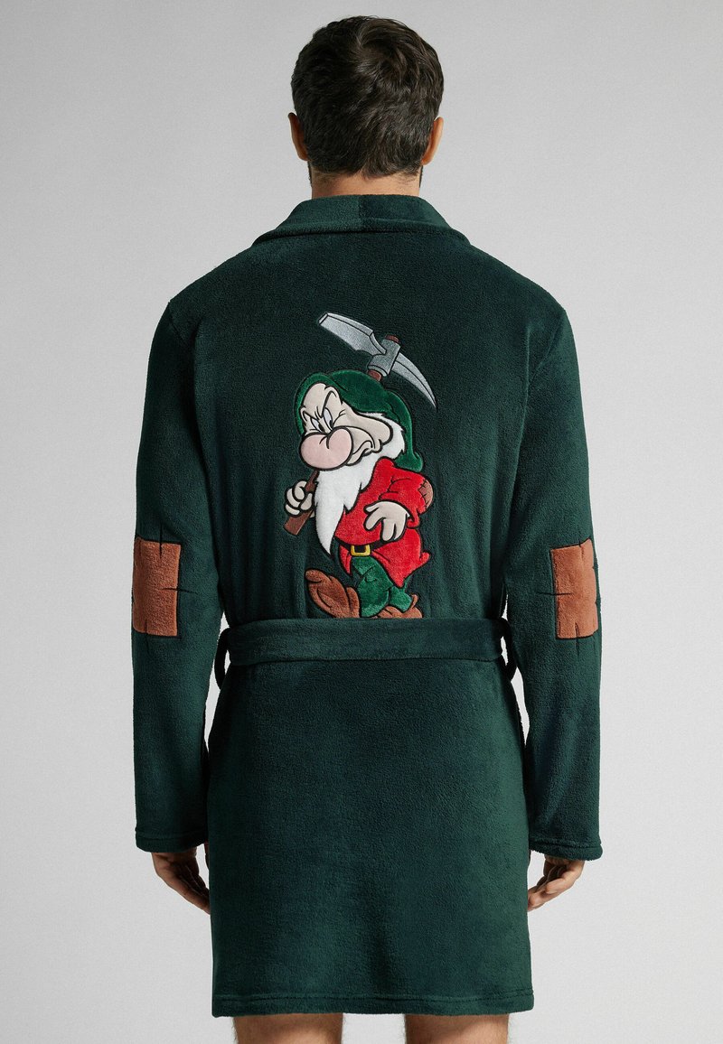 Zielona flanelowa szlafrok z haftowanym motywem postaci krasnoluda na plecach, brązowymi łaty na łokciach i paskiem do wiązania. Miękka tekstura.